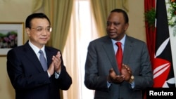 Chinese Premier Li Keqiang, left, and Kenyan President Uhuru Kenyatta applaud signing of a Standard Gauge Railway agreement at the State House in Nairobi, May 11, 2014. Fraud has been alleged in a railway deal. 