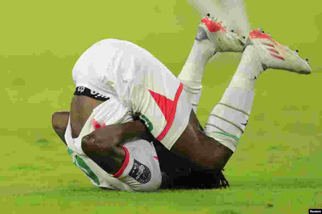 Burkina Faso&#39;s Issa Kabore reacts after sustaining an injury.