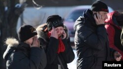 5일 우크라이나 동부 도네츠크에서 교전이 발생해 사망자가 발생한 가운데, 유가족들이 사망한 가족 옆에서 울고 있다.