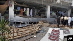 Pakistani security officials examine the site of a suicide bombing in Islamabad, Pakistan. A suicide bomber blew himself up at a busy market in the Pakistani capital, killing at least one person in the first bombing in Islamabad in over a year and a half,
