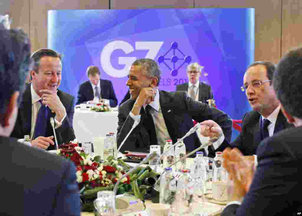 U.S. President Barack Obama laughs as he looks at British Prime Minister David Cameron during a G7 session in Brussels, June 5, 2014.