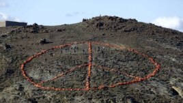 Volunteers from non-governmental organizations (NGO) arrange more than 2,500 discarded lifejackets, used by refugees and migrants, in the shape of the peace symbol on the Greek island of Lesbos, Jan. 1, 2016.