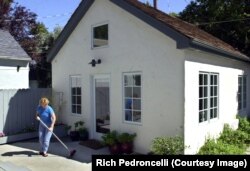FILE: Christine Minnehan sweeps up in front of her "granny flat" located in the backyard of her Sacramento, Calif home. It is an example of second homes property owners can rent to others. June 27, 2002.
