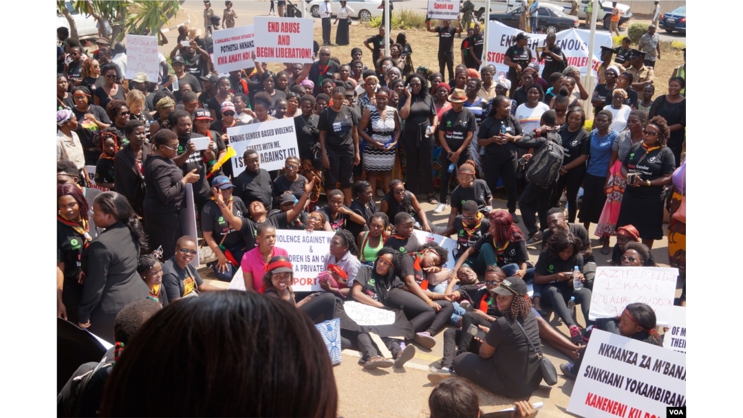 Some marchers lie on the streets of Lilongwe, symbolizing mourning for victims of domestic violence in Malawi, Sept. 14, 2017. (L. Masina/VOA)