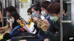 南韓人戴上口罩乘坐地鐵，以防感染中東呼吸綜合症病例。