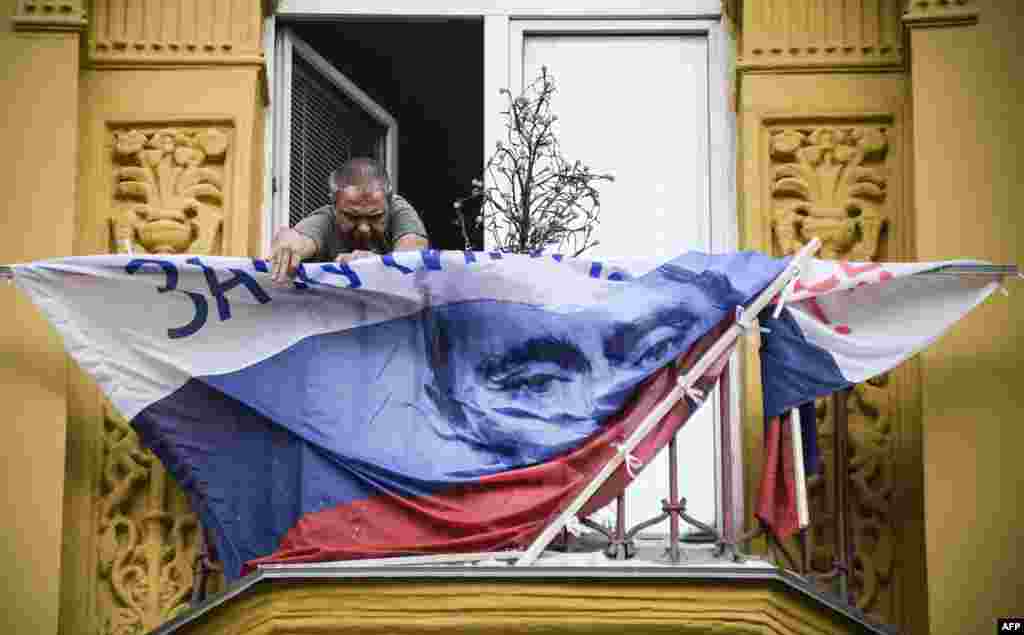A man fixes a Russian campaign flag of President Vladimir Putin on the balcony of his apartment in Moscow.
