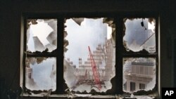FILE - In this Sept. 20, 2001 file photo, ground zero is seen through a shattered window of an 18th floor apartment overlooking the World Trade Center site. After the 9/11 attacks, there were grim predictions about the future of the shaken, dust-covered