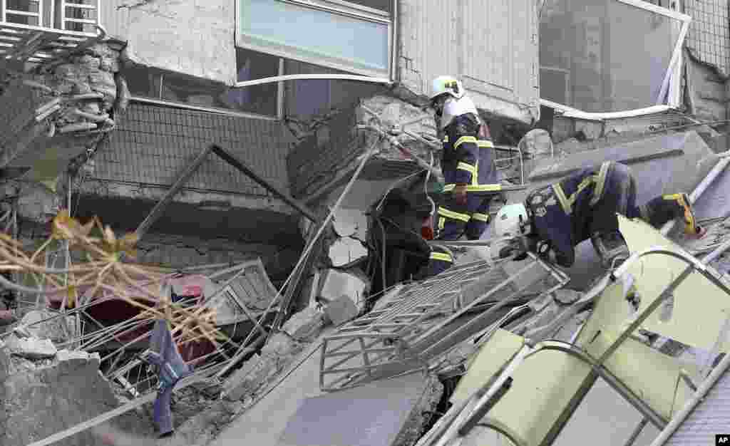Emergency rescue teams search for victims in a crumbled building. 