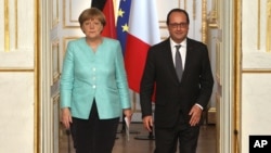 France's President Francois Hollande, right, and German chancellor Angela Merkel arrive to give a press conference, at the Elysee Palace, in Paris, July 6, 2015. 