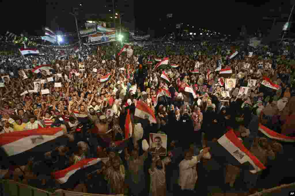 Supporters of ousted Egypt's President Mohamed Morsi hold his portraits and wave Egyptian flags as they shout slogans during a demonstration after the Iftar prayer in Nasr City, Cairo, July 10, 2013.