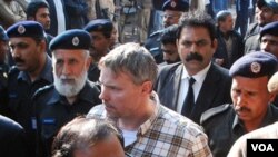 Polisi Pakistan mengawal diplomat AS, Raymond Davis menuju pengadilan di kota Lahore. Davis diadili atas tuduhan melakukan pembunuhan.