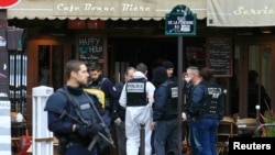 Police investigators work at the scene of a shooting in a bar in Rue de le Fontaine the morning after a series of deadly attacks in Paris , Nov. 14, 2015. 