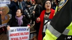 Yong Soo Lee, lower left, of South Korea, protests outside the John F. Kennedy School of Government in Cambridge, Mass., where Japanese Prime Minister Shinzo Abe spoke, Monday, April 27, 2015