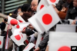 Well-wishers wait as Japan's Emperor Akihito with his family members appear on the balcony of the Imperial Palace to mark the emperor's 85th birthday in Tokyo, Dec. 23, 2018.