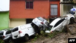 Voitures balayées lors d'inondations causées par la tempête tropicale Cristobal à Panchimalco au Salvador, le 3 juin 2020. (Marvin Recinos/AFP)