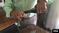 "Nabaz" pours a glass of his homemade wine "21 Rays," produced in Iraqi Kurdistan. (S. Behn/VOA)