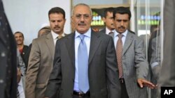 Yemeni President Ali Abdullah Saleh, center, surrounded by guards, arrives for a meeting with his supporters during a gathering in a soccer stadium in Sana'a, March 10, 2011