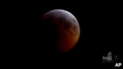 FILE - This image from video provided by Griffith Observatory in Los Angeles shows an impact flash on the moon (Bottom-L) during the lunar eclipse which started on Jan. 20, 2019. 