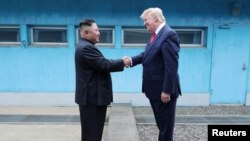 도널드 트럼프 미국 대통령과 김정은 북한 국무위원장이 지난해 6월 군사분계선에서 악수하고 있다. 