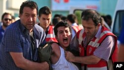 Turkish police arrest a protester chanting slogans in Istanbul after he and others tried to stage a march to denounce the deaths of a Monday explosion in the Turkish town of Suruc near the Syrian border, July 21, 2015.