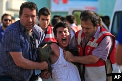 Turkish police arrest a protester chanting slogans in Istanbul after he and others tried to stage a march to denounce the deaths of a Monday explosion in the Turkish town of Suruc near the Syrian border, July 21, 2015.