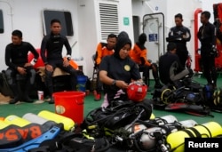 A group of divers prepares their gear on the deck of the Search and Rescue (SAR) ship KN Purworejo during a search operation for passengers onboard AirAsia Flight 8501 in the Java Sea, Jan. 4, 2015.