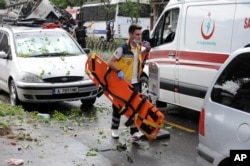 A Turkish medic rushes in to work at the explosion site after a bus carrying riot police official was struck by a bomb in Istanbul, Tuesday, June 7, 2016.