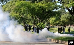 Venezuelan Bolivarian National Guard officers fire tear gas toward residents that try to walk to the Paramacay military base in Valencia, Venezuela, Aug. 6, 2017.