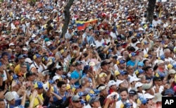 Anti-government protesters listen to Venezuelan Congress President Juan Guaido, an opposition leader who declared himself interim president, during a rally demanding the resignation of Venezuelan President Nicolas Maduro in Caracas, March 4, 2019.