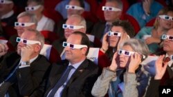 French National Centre for Space Studies (CNES) president Jean-Yves Le Gall, left, French President Francois Hollande, center, and former French minister and astronaut Claudie Haignere, right, wear 3D glasses as they visit the Cite des Sciences at La Villette during a broadcast of the Rosetta mission as it orbits around comet 67/P Churyumov-Gersimenko in Paris, Wednesday, Nov. 12, 2014. Hundreds of millions of miles from Earth, a European spacecraft made history Wednesday by successfully landing on the icy, dusty surface of a speeding comet — an audacious first designed to answer big questions about the universe. (AP Photo/Jacques Brinon, Pool)