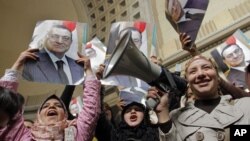 Para pendukung mantan Presiden Hosni Mubarak merayakan keputusan pengadilan Mesir yang memerintahkan persidangan ulang atas mantan Presiden tersebut di Kairo hari Minggu (13/1).