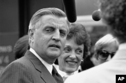Former Vice President Walter Mondale, left, and his wife, Joan Mondale, face reporters following the presidential candidates appearance on the NBC-TV program Meet the Press, Sept. 10, 1984, Washington, D.C.