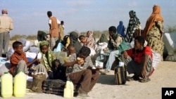 FILE - Somali refugees wait for a plane to take them home from Dabaab refugee camp in northern Kenya, Feb. 21, 2000.