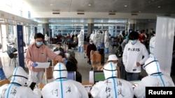 海外抵達北京的旅客在北京國際會展中心接受登記檢測與分流。（2020年3月18日）