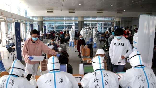 海外抵达北京的旅客在北京国际会展中心接受登记检测与分流。（2020年3月18日）
