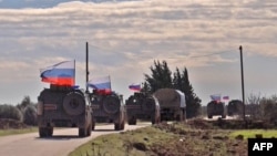 An image grab taken from AFP TV, Jan. 17, 2019, shows Russian army vehicles on patrol in the area of Arimah, just west of Manbij, the northern city near the Turkish border where a day earlier a suicide attack on a restaurant killed four Americans.