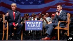 Republican presidential candidate Donald Trump gives a thumbs up as he speaks with retired Lt. Gen. Michael Flynn during a town hall in Virginia Beach, Va., Sept. 6, 2016.