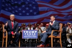 FILE - Donald Trump gives a thumbs up as he speaks with retired Lt. Gen. Michael Flynn during a town hall in Virginia Beach, Virginia, Sept. 6, 2016.