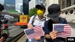 兩名香港市民7月4日美國獨立日手持A4紙印的美國國旗到美國領事館附近慶祝。(美國之音 湯惠芸拍攝)