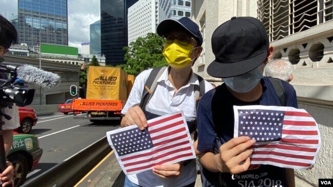 兩名香港市民7月4日美國獨立日手持A4紙印的美國國旗到美國領事館附近慶祝。(美國之音 湯惠芸拍攝)
