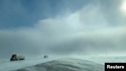 Trucks drive amidst heavy snow near Fargo, North Dakota, U.S., January 29, 2019, in still image taken from a video taken from social media. Carol Bauer/via REUTERS