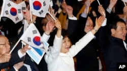 South Korean President Park Geun-hye, center, cheers with her national flag during a ceremony to celebrate the Independence Movement Day, in Seoul, March 1, 2014. 