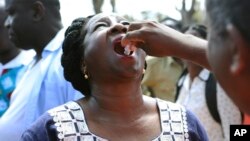 FILE - A government official receives an oral cholera vaccination at a camp for displaced survivors of cyclone Idai in Beira, Mozambique, April, 3, 2019. 