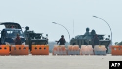 Soldiers stand guard on a blockaded road to Myanmar's parliament in Naypyidaw on February 1, 2021, after the military detained the country's de facto leader Aung San Suu Kyi and the country's president in a coup. (Photo by STRINGER / AFP)