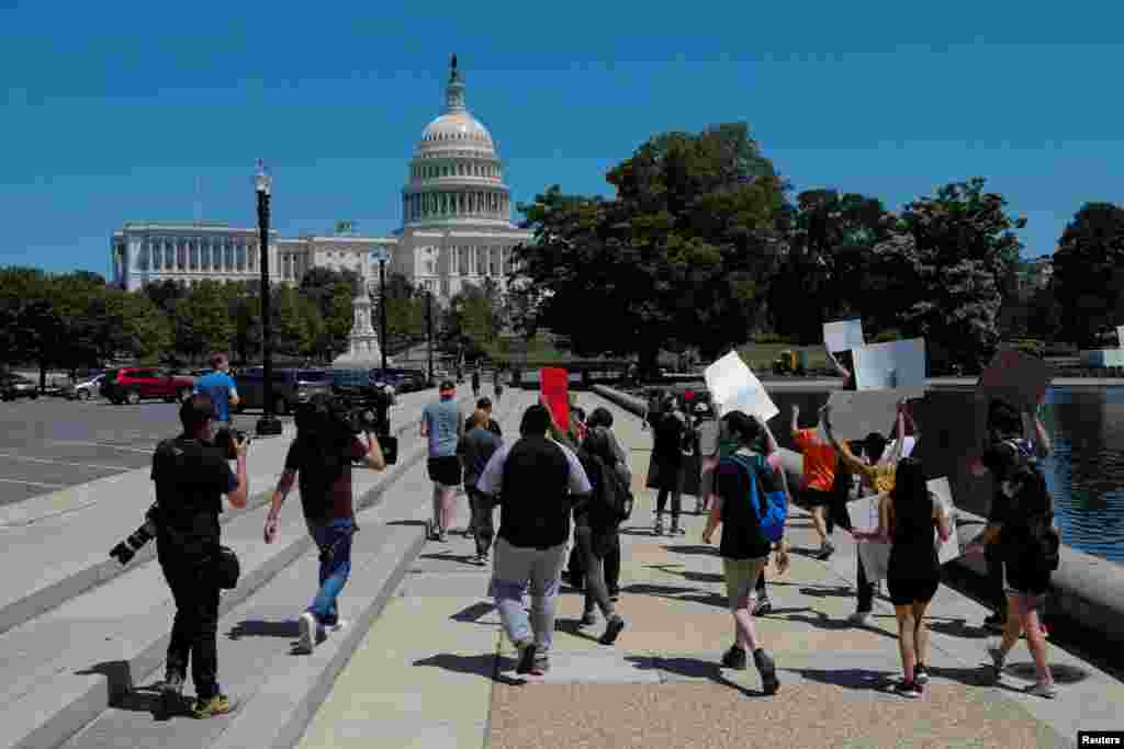 Este s&#225;bado, manifestantes sostienen pancartas mientras marchan hacia el Capitolio, en Washington.