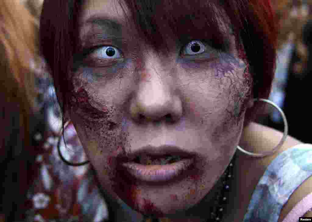 Seorang peserta berpakaian seperti zombie selama pawai acara Halloween untuk mempromosikan serial TV baru AS "The Walking Dead" di Tokyo.