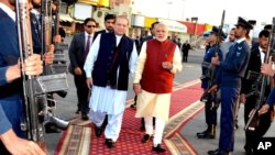 In this photo released by Press Information Department, India's Prime Minister Narendra Modi, right, reviews a guard of honor with his Pakistani counterpart, Nawaz Sharif, in Lahore, Pakistan, Dec. 25, 2015.