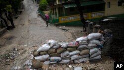 A barricade blocks off half of an entrance for vehicles, in Port-au-Prince, Haiti, June 3, 2023. The blockade was erected by the bwa kale movement, an initiative to fight gangs seeking to take control of neighborhoods. 