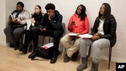 FILE - Young job seekers wait to meet with recruiters during a job fair hosted by the Gregory Jackson Center for Brownsville, in the Brooklyn borough of New York.