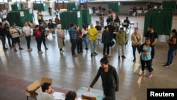 Una fila de electores esperan su turno para votar en un referendo para una nueva Constitución en Santiago de Chile, el 17 de diciembre de 2023.